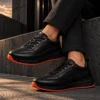 Tenis 3205 Eva Runner Negro con Naranja — Sentado · tobillos cruzados